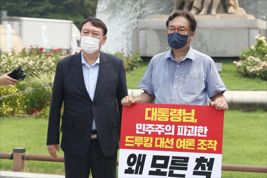 지난 7월29일 윤석열(왼쪽) 대선 예비후보가 서울 종로구 청와대 앞 분수대 광장에서 드루킹 댓글 조작 사건과 관련해 문재인 대통령의 사과를 촉구하며 1인 시위를 하고 있는 국민의힘 정진석 의원을 격려방문, 발언하고 있다.연합뉴스·국회사진기자단